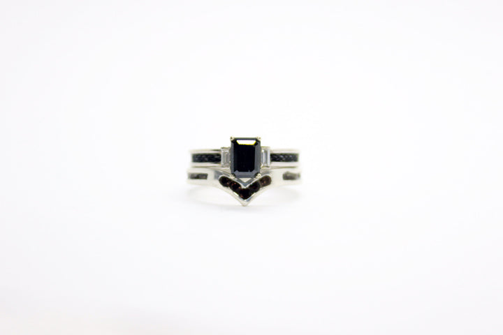 White gold, diamond and black diamond horsehair ring sitting on top of a white gold horsehair ring with smokey quartz stones, on a white background