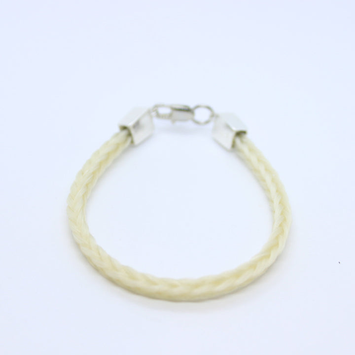 White braided horsehair  bracelet with platinum ends on a bright white background