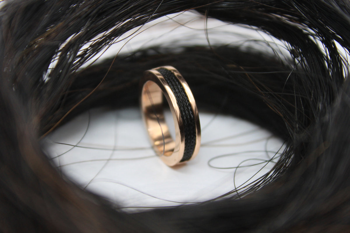 Woven horsehair ring set into 14k roe gold set into the center of coiled up horsehair